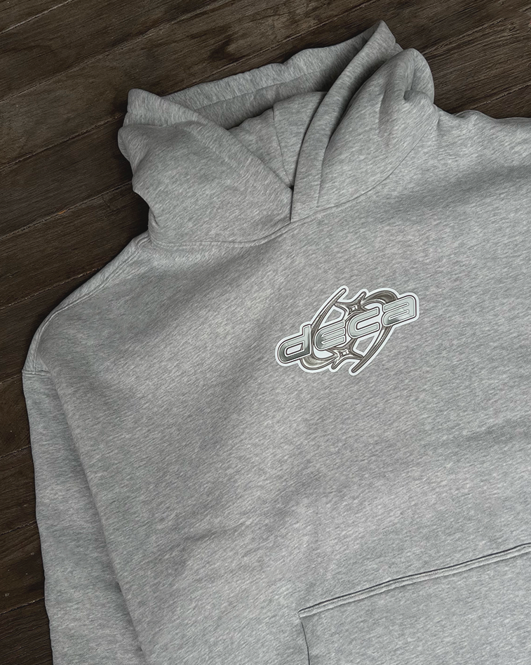 Gray hoodie with a logo on the chest, laid flat on a wooden surface