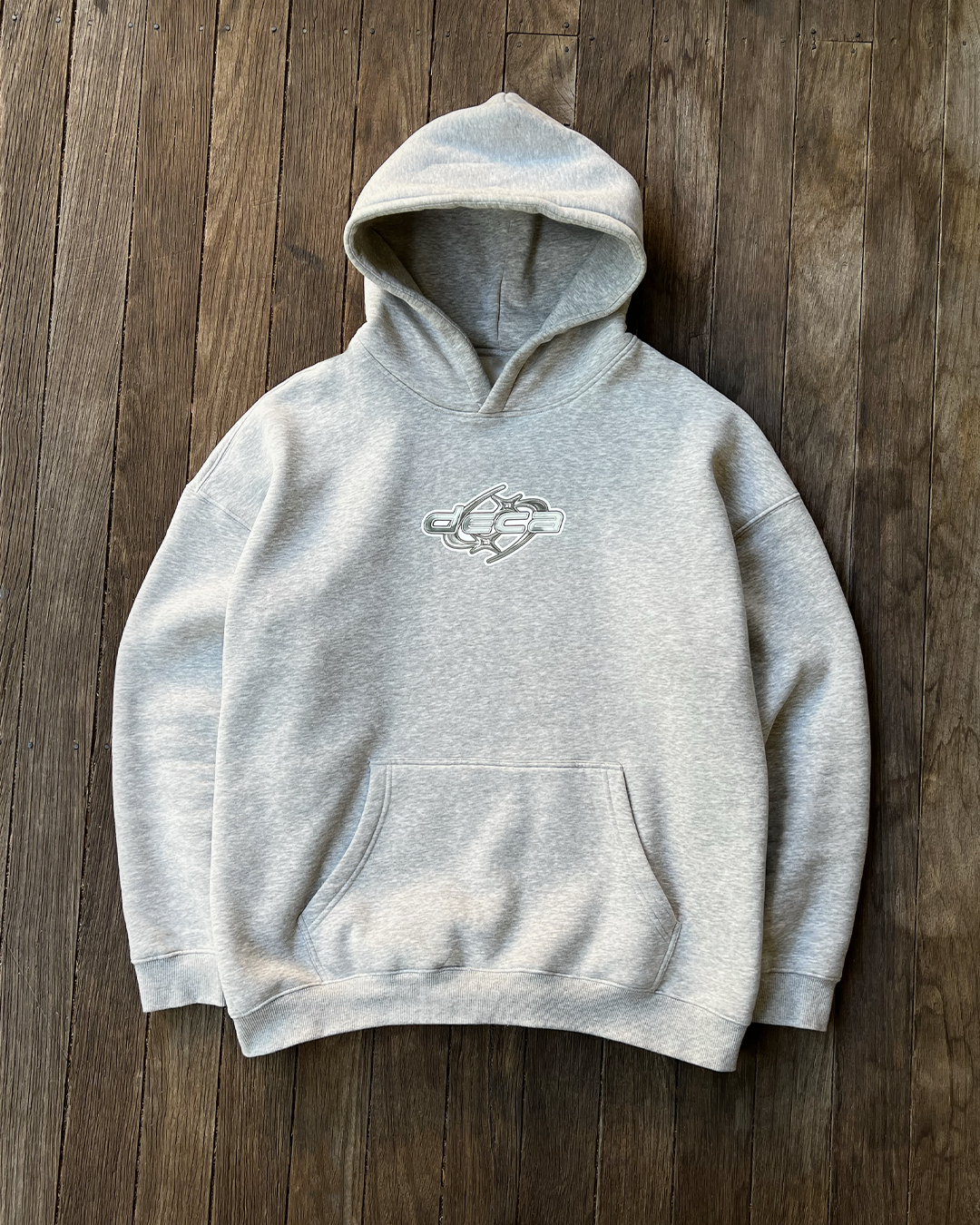 Gray hoodie with a an abstract logo on a wooden surface